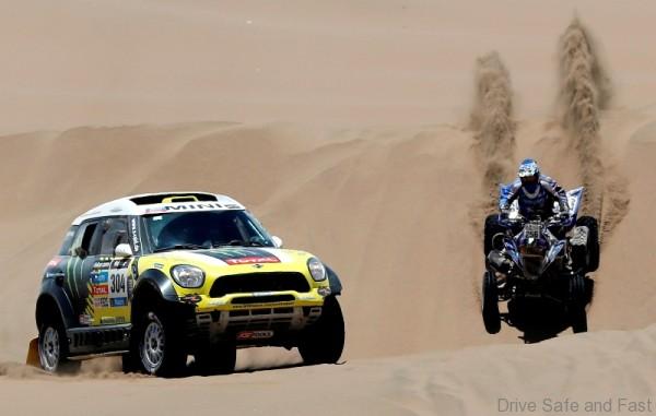 Nani Roma of Spain (L) drives his Mini beside Sergio Lafuente of Uruguay on his Yamaha quad during the ninth stage of the Dakar Rally 2014, from Calama to Iquique, January 14, 2014. REUTERS/Jean-Paul Pelissier (CHILE - Tags: SPORT MOTORSPORT)