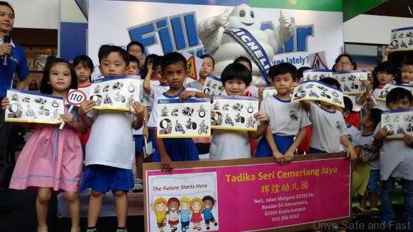 Children from Seri Cemerlang Jaya Kindergarten receiving Michelin Man stickers and a school bag as a reward for their effort in completing the activities