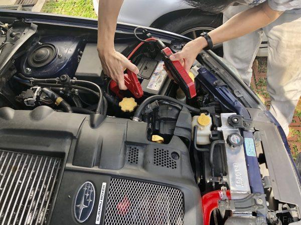 car battery delivery service technician checks battery health