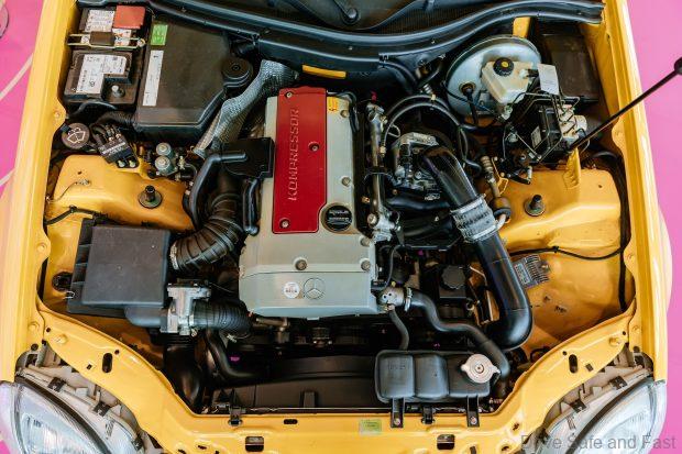 Mercedes-Benz SLK 230 Kompressor (Baureihe R 170) in der Kommunikationsfarbe yellowstone (Mercedes-Benz Farbcode 685). Detailaufnahme des Motorraums aus dem Jahr 2025 aus der Sonderausstellung „Youngtimer“ im Mercedes-Benz Museum. Foto: Thomas Niedermüller. (Fotosignatur der Mercedes-Benz Classic Archive: D854680) 

Mercedes-Benz SLK 230 KOMPRESSOR (R 170) in the signature colour yellowstone (Mercedes-Benz colour code 685). Detailed view of the engine compartment, from the year 2025, at the special “Youngtimer” exhibition at the Mercedes-Benz Museum. Photo: Thomas Niedermüller. (Photo index number in the Mercedes-Benz Classic Archive: D854680)